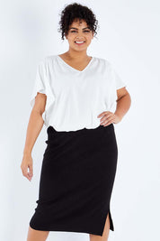 Model Sasha-Lee wearing size XL of The Ribbed Knit Skirt in colour Black (Black), from the front, cropped image