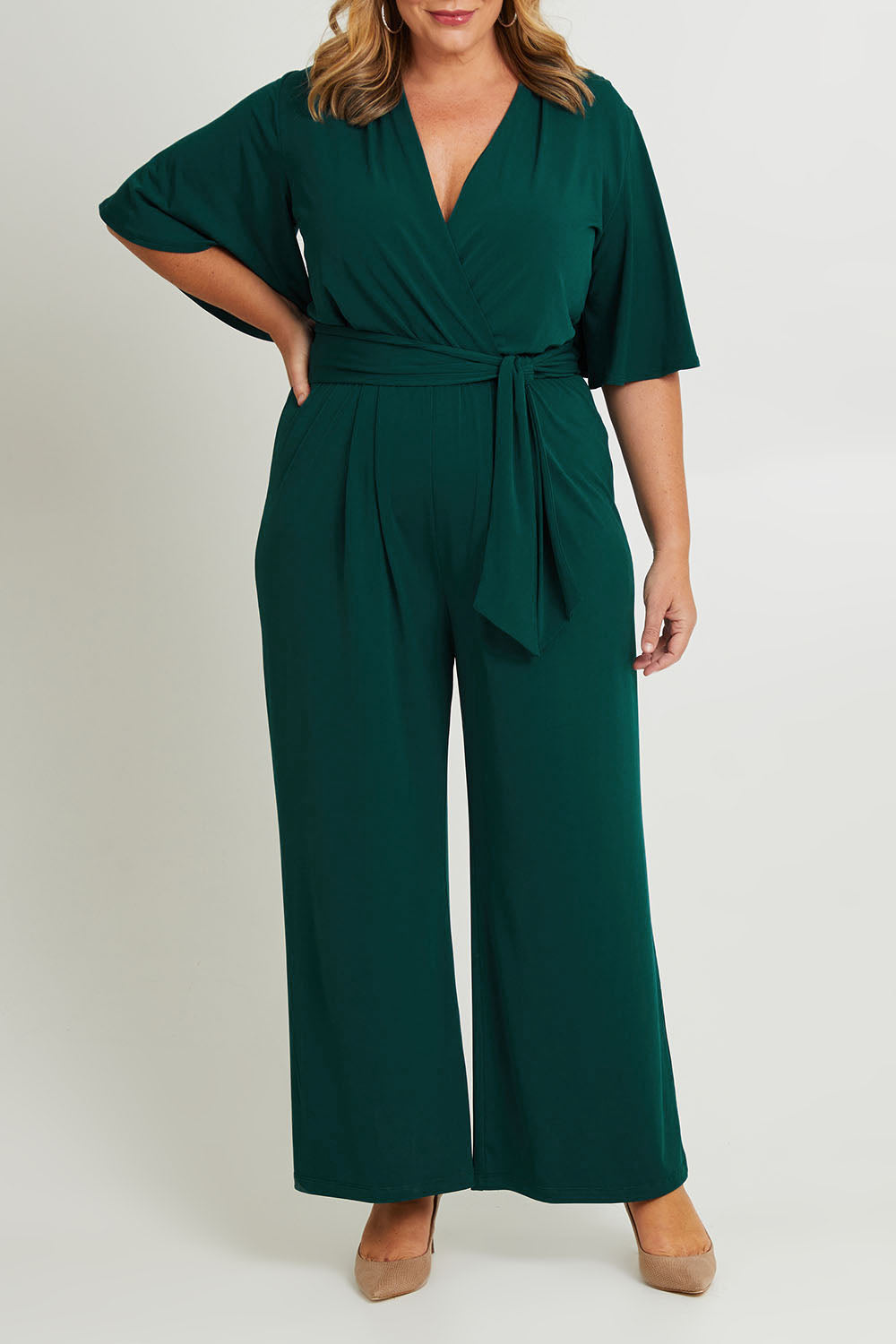 Model Fiona wearing size 16 of The Bell Sleeve Jumpsuit in colour Pine (Green), from the front, cropped image