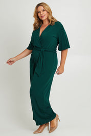 Model Fiona wearing size 16 of The Bell Sleeve Jumpsuit in colour Pine (Green), from the front, showing the whole outfit