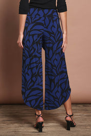 Model Madeline wearing size 10 of The Printed Cross Over Pant in colour Bluevines (Blue), from the back