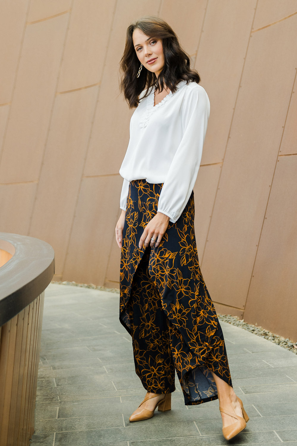 Model Andrea wearing size 10 of The Printed Cross Over Pant in colour Navyfloral (Blue), from the front, showing the whole outfit