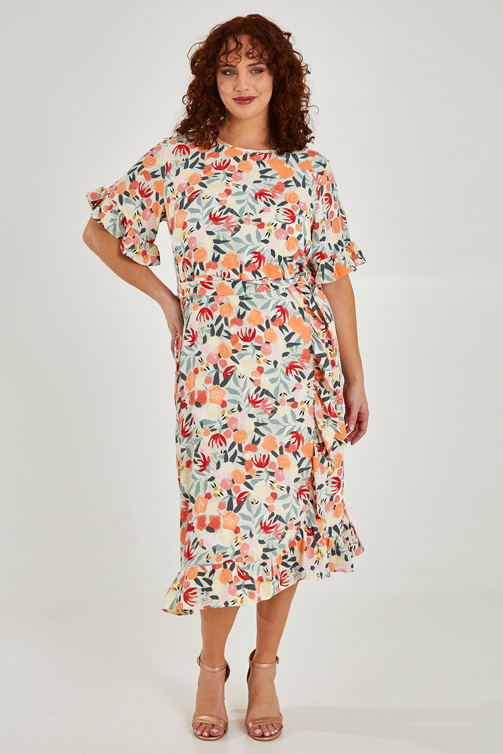Model Maddy wearing size 16 of The Lined Kimono Sleeve Ruffle Hem Dress in colour Orchard, from the front, showing the whole outfit