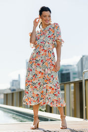 Model Miranda wearing size 10 of The Lined Kimono Sleeve Ruffle Hem Dress in colour Orchard, from the front, showing the whole outfit