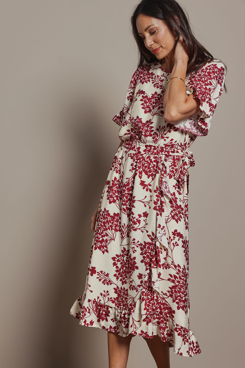 Model Amanda wearing size 10 of The Lined Kimono Sleeve Ruffle Hem Dress in colour Winebloom (Red), from the front, cropped image