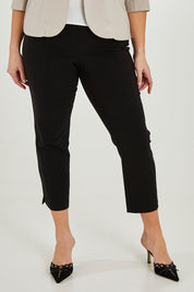 Model Maddy wearing size 16 of The 7/8 Pocket Pull On Pant in colour Black (Black), from the front, cropped image