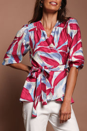 Model Amanda wearing size 10 of The Printed Blouson Sleeve Wrap Blouse in colour Pinkleaf (Pink), from the front, cropped image
