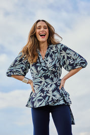 Model Clementine wearing size 10 of The Printed Blouson Sleeve Wrap Blouse in colour Navyleaf (Blue), from the front, showing the whole outfit