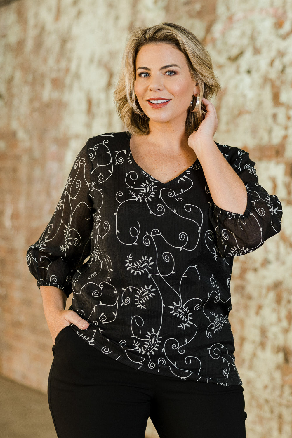 Model Fiona wearing size 16 of The Lined V Neck Blouse in colour Vines (Black), from the front, showing the whole outfit