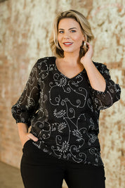 Model Fiona wearing size 16 of The Lined V Neck Blouse in colour Vines (Black), from the front, showing the whole outfit