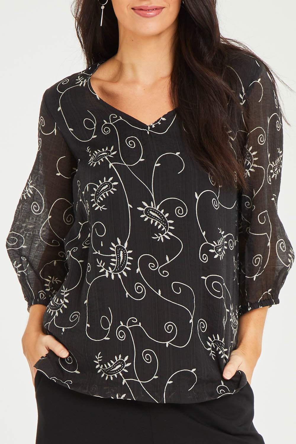 Model Stacey wearing size 10 of The Lined V Neck Blouse in colour Vines (Black), from the front, cropped image
