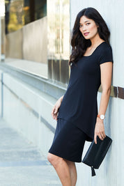 Model Miranda wearing size 10 of The Short Sleeve Rita Dress in colour Black (Black), from the front, showing the whole outfit