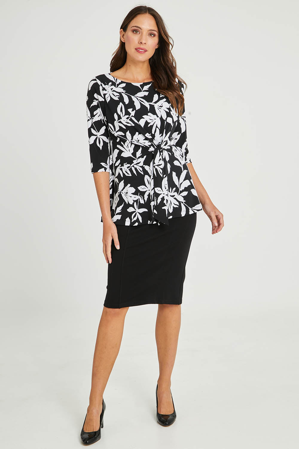 Model Madeline wearing size 10 of The Tie Detail Top in colour Lily (Black), from the front, showing the whole outfit