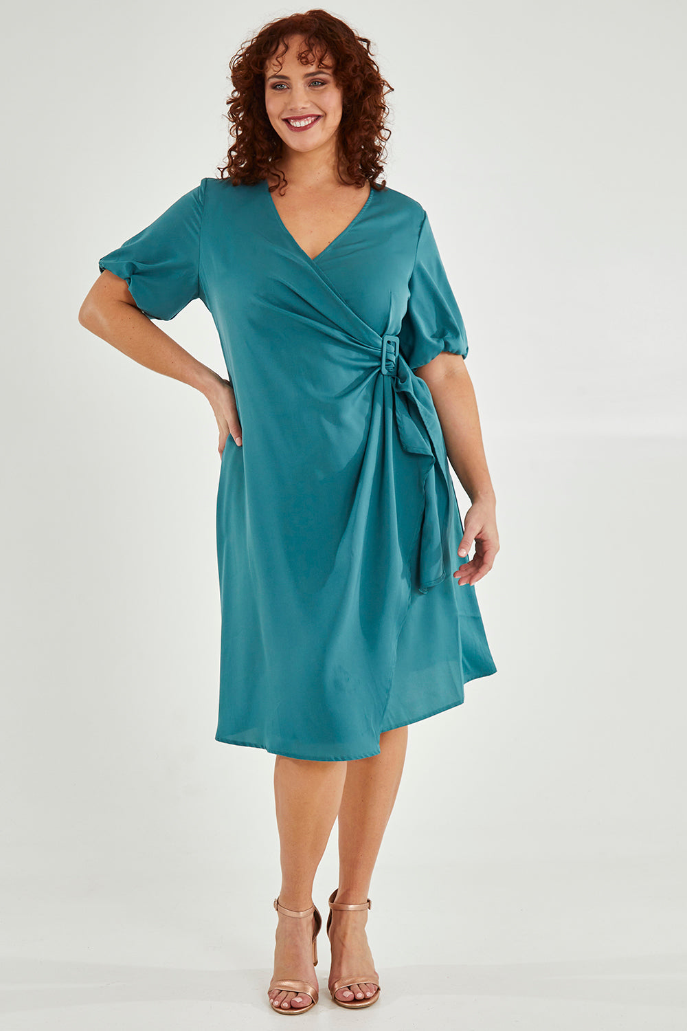 Model Maddy wearing size 16 of The Buckle Detail Faux Wrap Dress in colour Lagoon (Green), from the front, showing the whole outfit