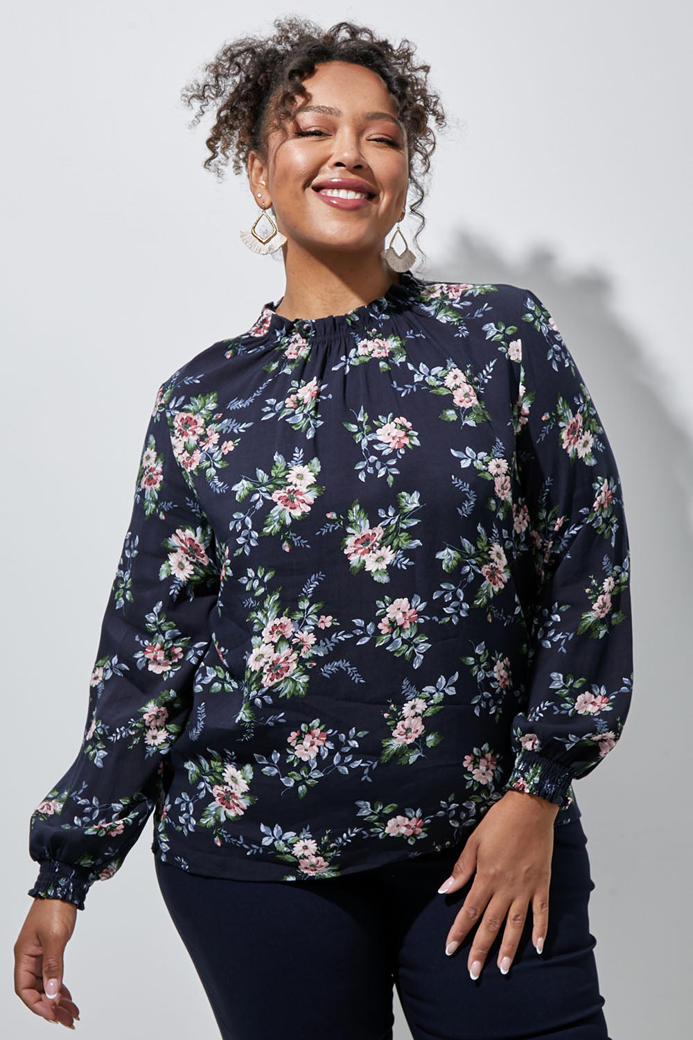 Model Alexis wearing size 16 of The Smocking Detail Printed Top in colour Flower (Blue), from the front, showing the whole outfit