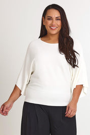 Model Ashleigh wearing size XL of The Transeasonal Kimono Knit in colour Snow (White), from the front, cropped image
