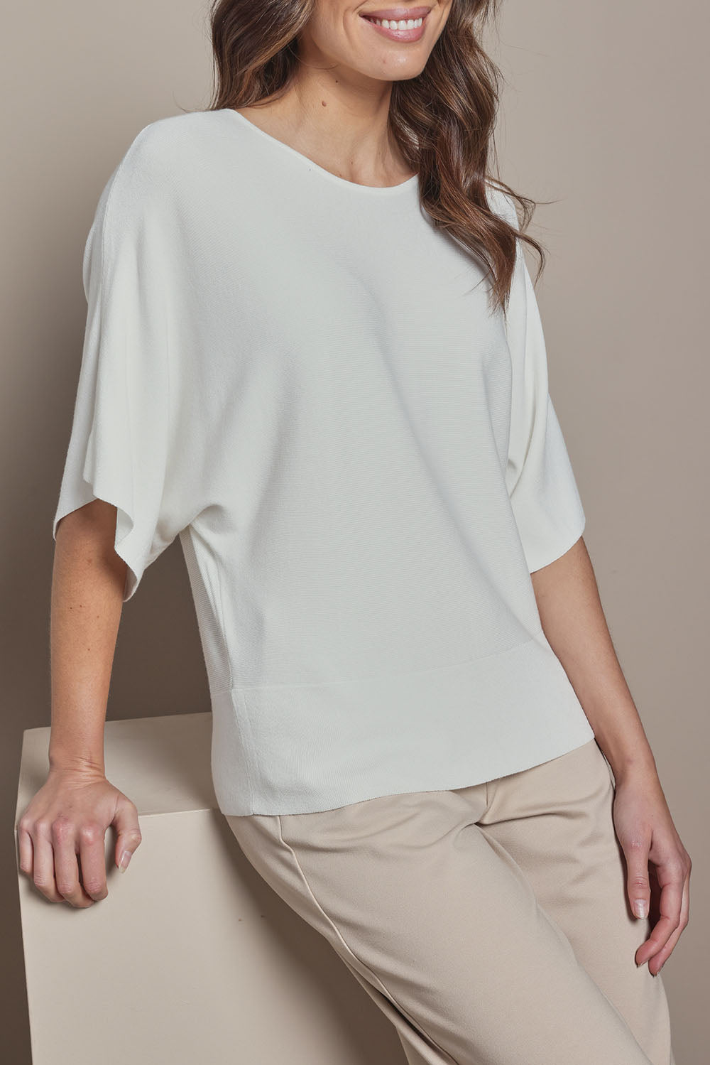 Model Madeline wearing size S of The Transeasonal Kimono Knit in colour Snow (White), from the front, cropped image