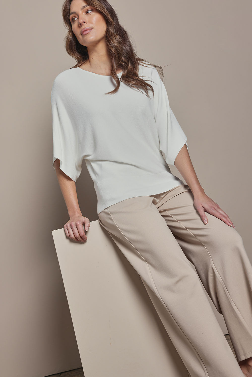 Model Madeline wearing size S of The Transeasonal Kimono Knit in colour Snow (White), from the front, cropped image