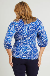 Model Fiona wearing size 18 of The Printed Knot Waist Detail Blouse in colour Fern (Blue), from the back