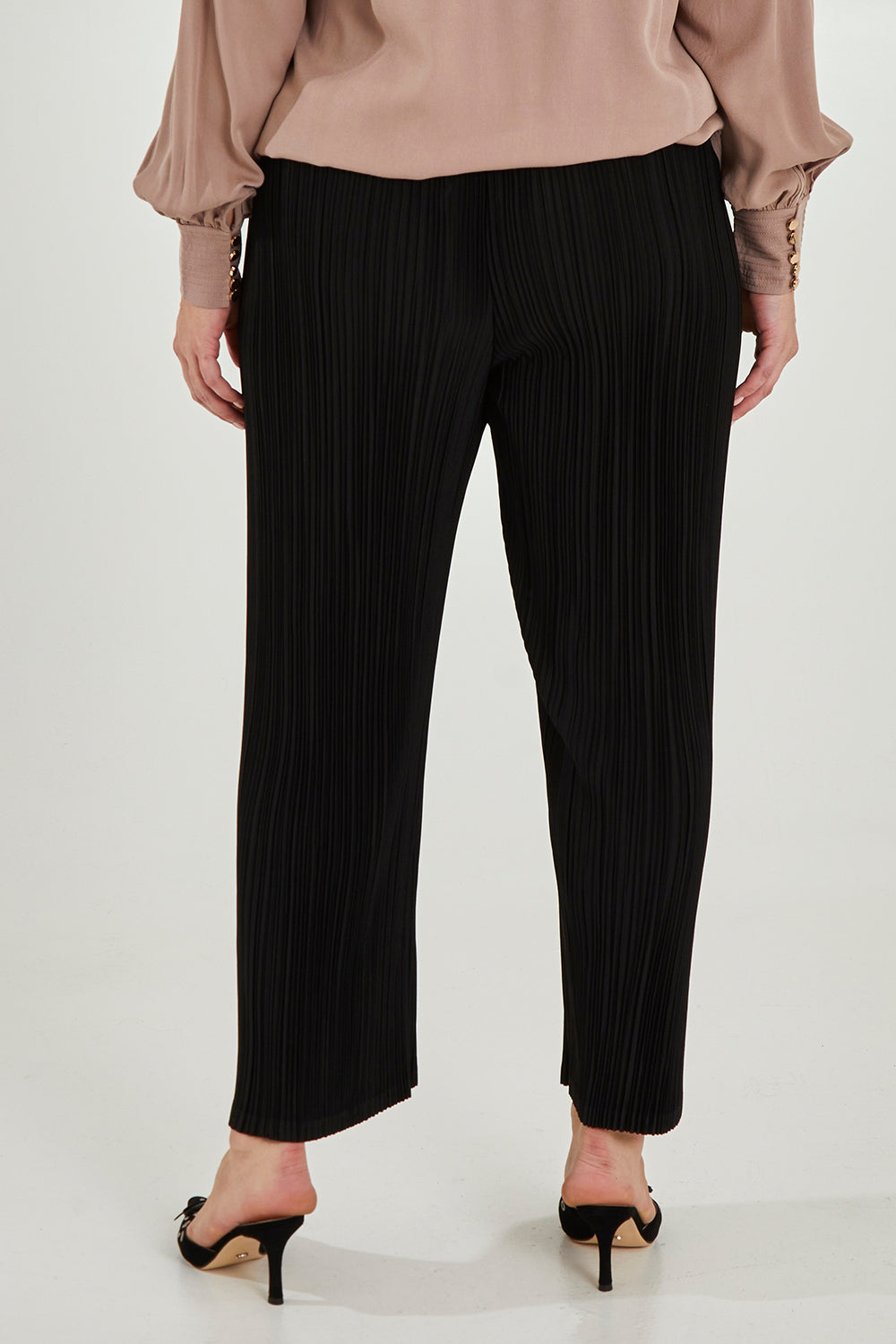 Model Maddy wearing size 16 of The Timeless Plisse Travel Pant in colour Black (Black), from the back