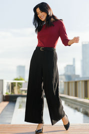 Model Miranda wearing size 10 of The Timeless Plisse Travel Pant in colour Black (Black), from the front, showing the whole outfit