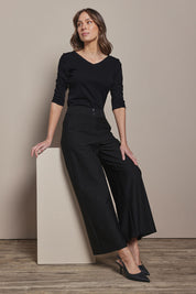 Model Madeline wearing size 10 of The Stripe Ponte Wide Leg Pant in colour Tanstripe (Black), from the front, showing the whole outfit