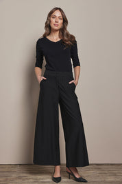 Model Madeline wearing size 10 of The Stripe Ponte Wide Leg Pant in colour Tanstripe (Black), from the front, showing the whole outfit