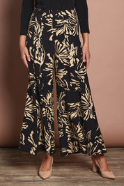 Model Madeline wearing size 10 of The Printed Flowy Panel Pull On Pant in colour Blackfleur (Black), from the front, cropped image