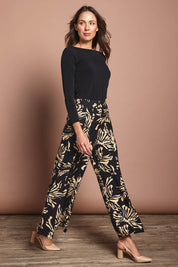 Model Madeline wearing size 10 of The Printed Flowy Panel Pull On Pant in colour Blackfleur (Black), from the front, showing the whole outfit