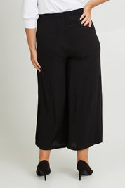 Model Fiona wearing size 16 of The Flowy Panel Pull On Pant in colour Black (Black), from the back