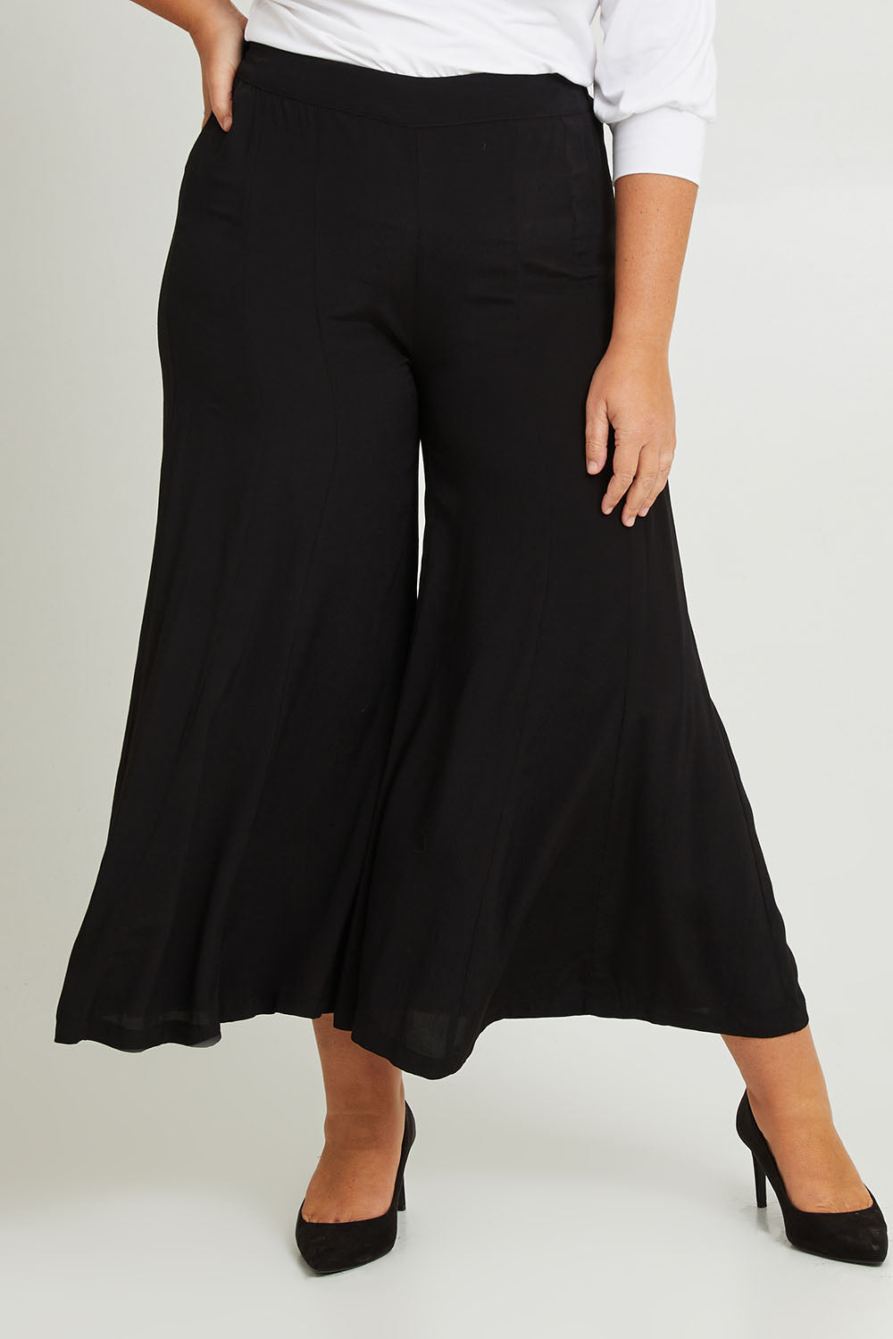 Model Fiona wearing size 16 of The Flowy Panel Pull On Pant in colour Black (Black), from the front, cropped image