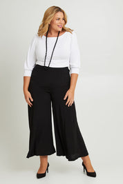 Model Fiona wearing size 16 of The Flowy Panel Pull On Pant in colour Black (Black), from the front, showing the whole outfit