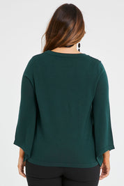 Model Laura wearing size L of The Cotton Cashmere Angled Sleeve Knit in colour Darkpine (Green), from the back