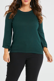 Model Laura wearing size L of The Cotton Cashmere Angled Sleeve Knit in colour Darkpine (Green), from the front, cropped image