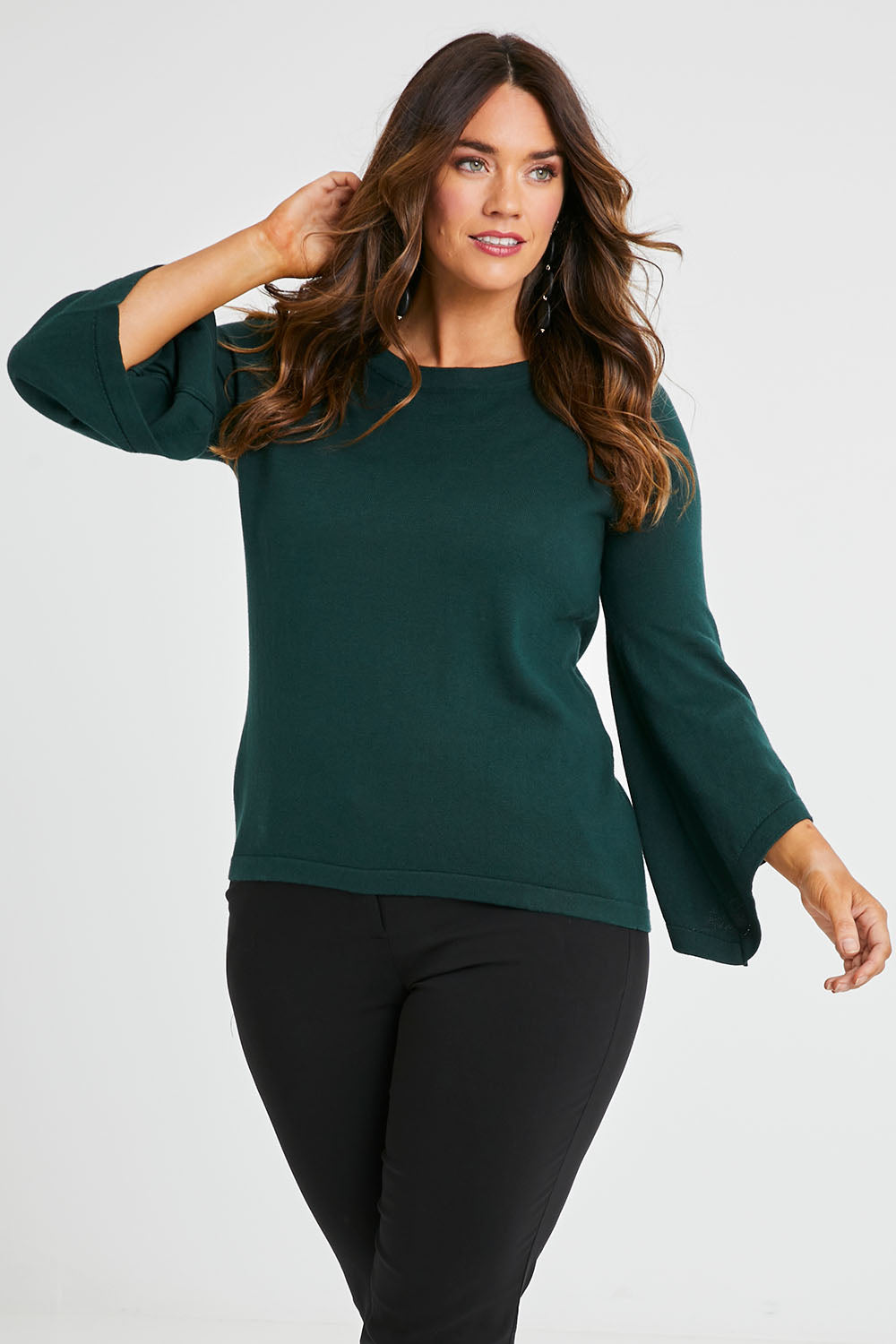Model Laura wearing size L of The Cotton Cashmere Angled Sleeve Knit in colour Darkpine (Green), from the front, cropped image