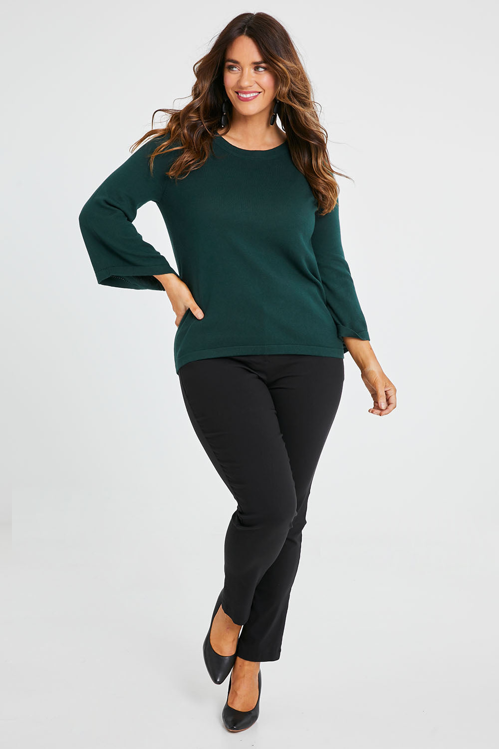 Model Laura wearing size L of The Cotton Cashmere Angled Sleeve Knit in colour Darkpine (Green), from the front, showing the whole outfit