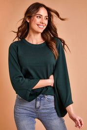 Model Madeline wearing size S of The Cotton Cashmere Angled Sleeve Knit in colour Darkpine (Green), from the front, showing the whole outfit