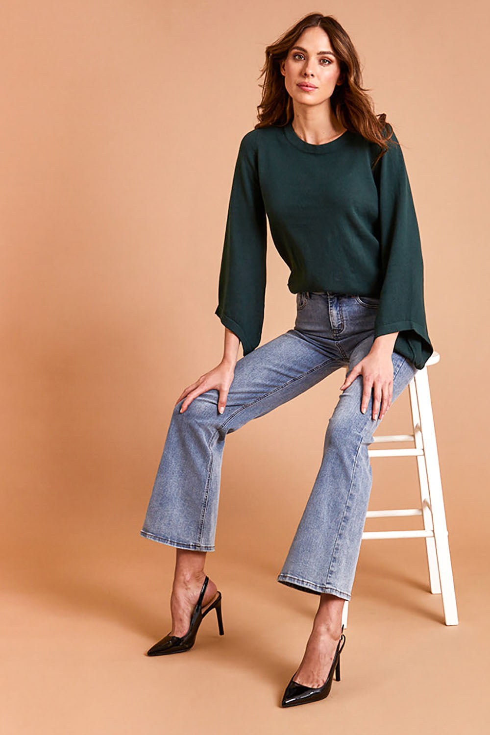 Model Madeline wearing size S of The Cotton Cashmere Angled Sleeve Knit in colour Darkpine (Green), from the front, showing the whole outfit