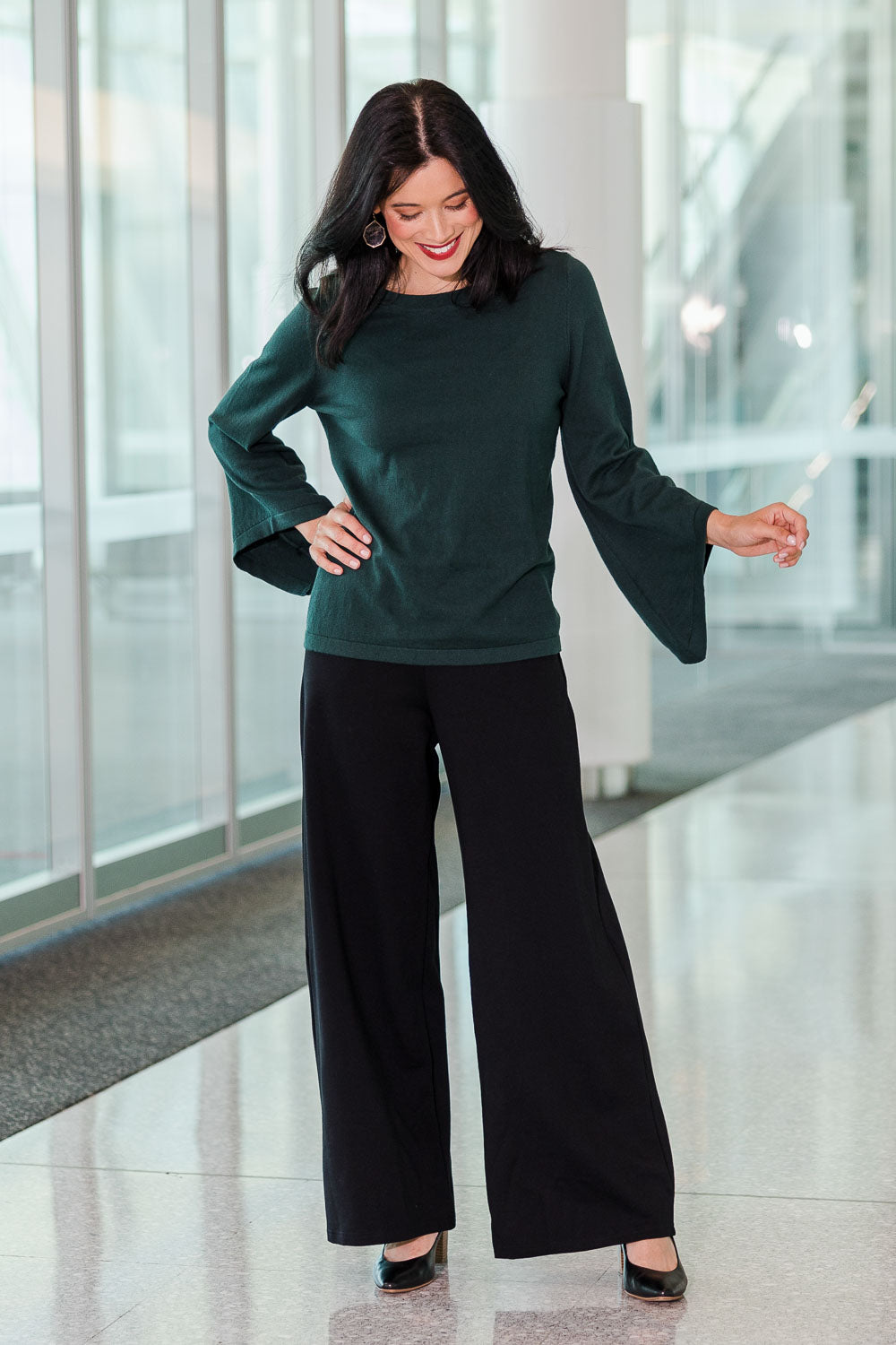 Model Miranda wearing size S of The Cotton Cashmere Angled Sleeve Knit in colour Darkpine (Green), from the front, showing the whole outfit