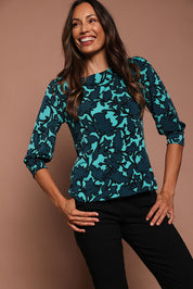 Model Amanda wearing size 10 of The Printed Boat Neck Blouse in colour Tealfleur (Green), from the front, showing the whole outfit