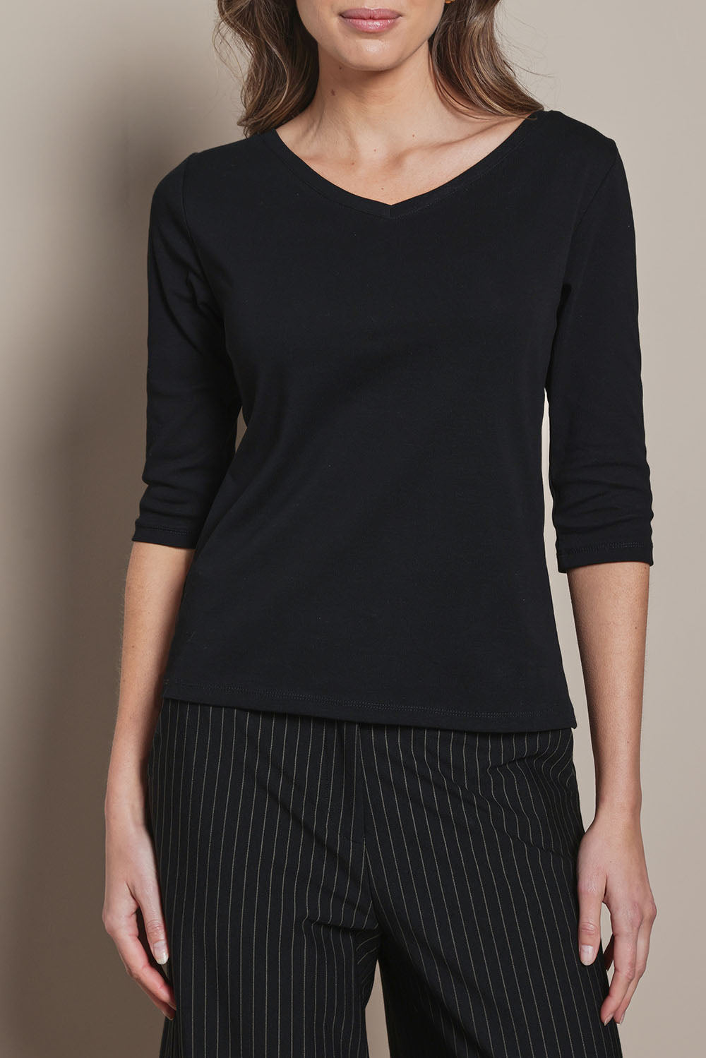Model Madeline wearing size 10 of The Reversible Cotton Stretch Top in colour Black (Black), from the front, cropped image