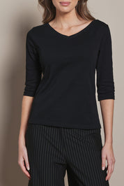 Model Madeline wearing size 10 of The Reversible Cotton Stretch Top in colour Black (Black), from the front, cropped image