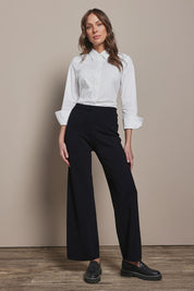 Model Madeline wearing size 10 of The Classic Cotton Stretch Shirt in colour White (White), from the front, showing the whole outfit