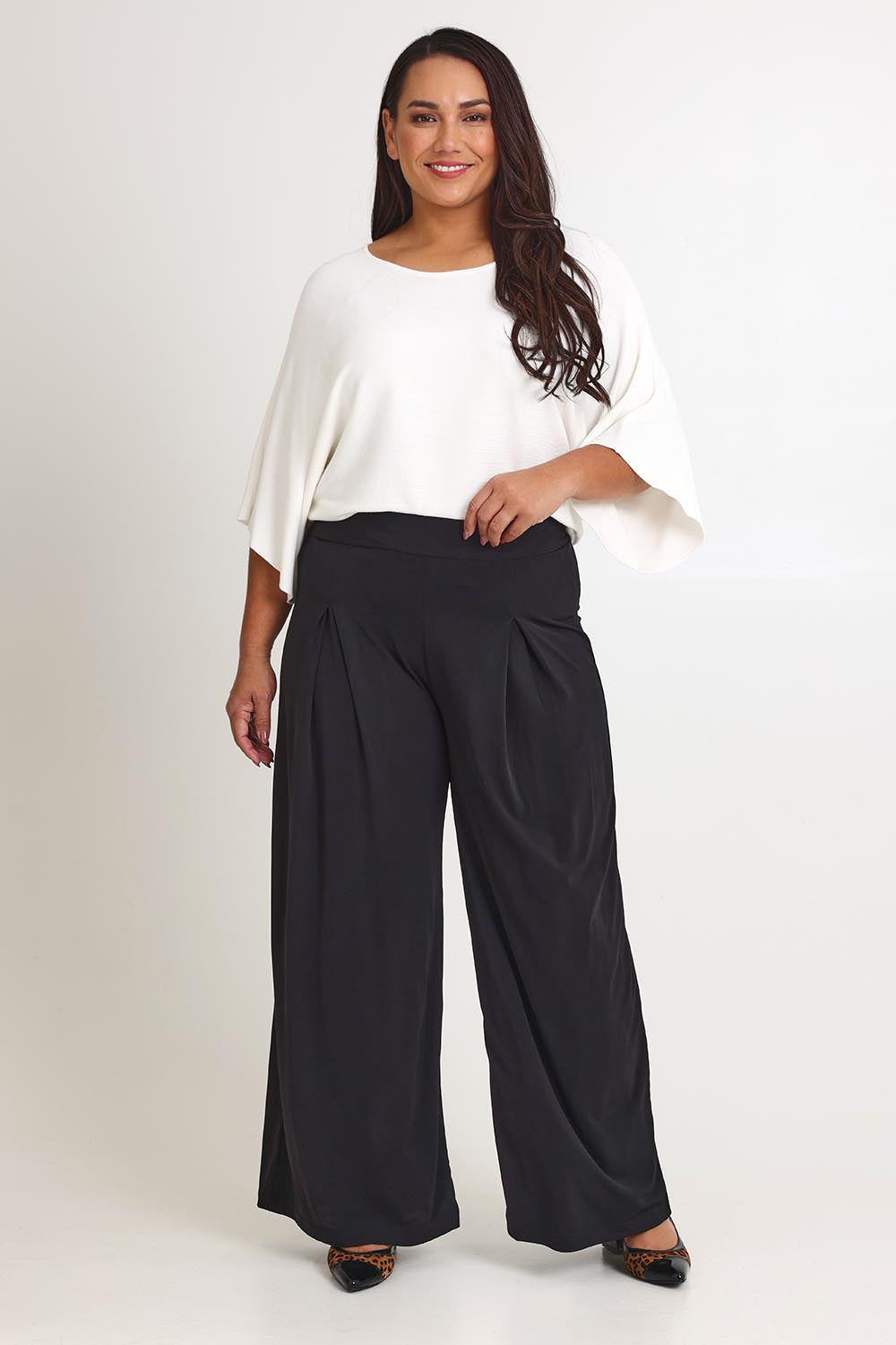 Model Ashleigh wearing size 16 of The Palazzo Jersey Pull On Pant in colour Black (Black), from the front, showing the whole outfit