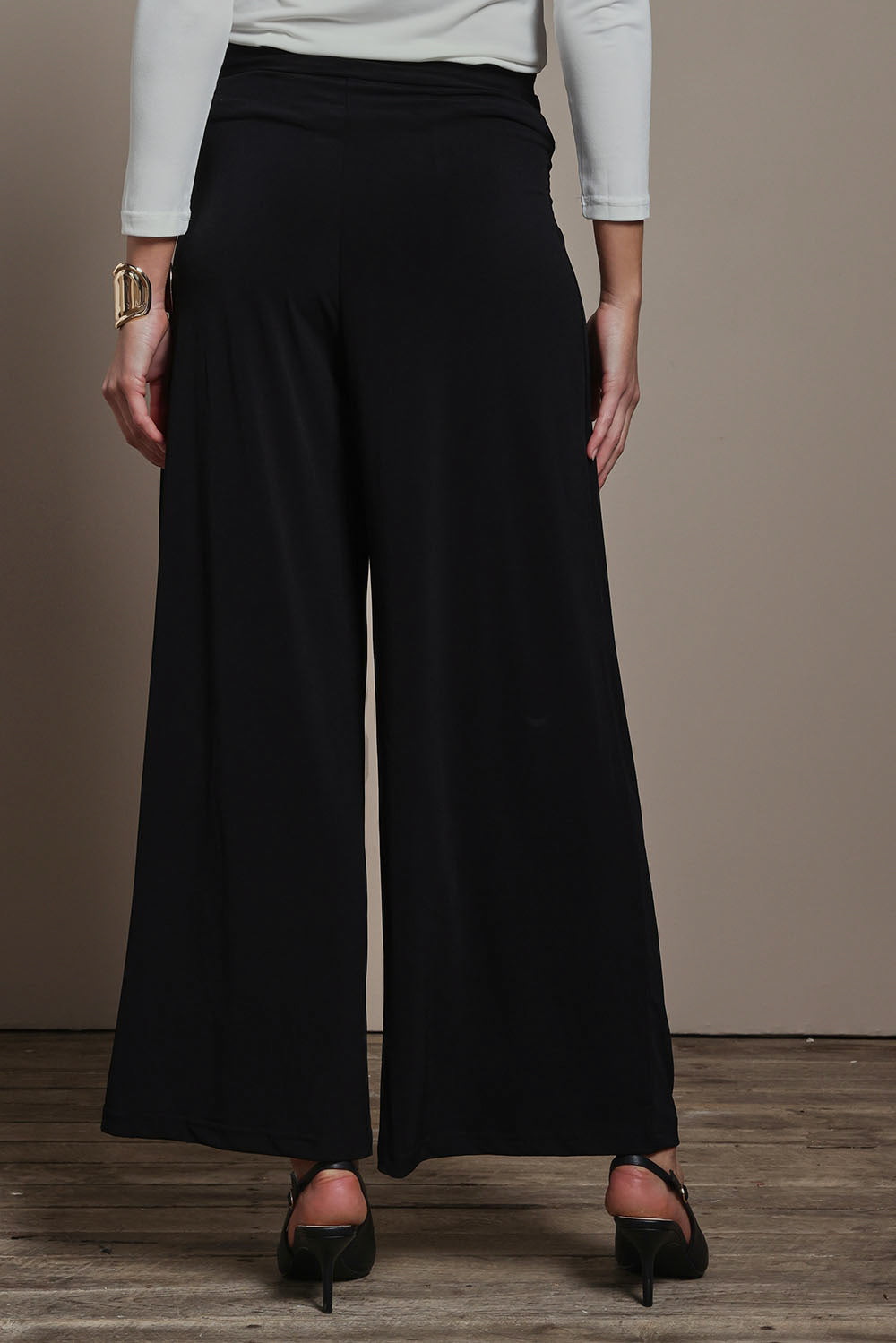 Model Madeline wearing size 10 of The Palazzo Jersey Pull On Pant in colour Black (Black), from the back