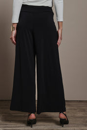 Model Madeline wearing size 10 of The Palazzo Jersey Pull On Pant in colour Black (Black), from the back