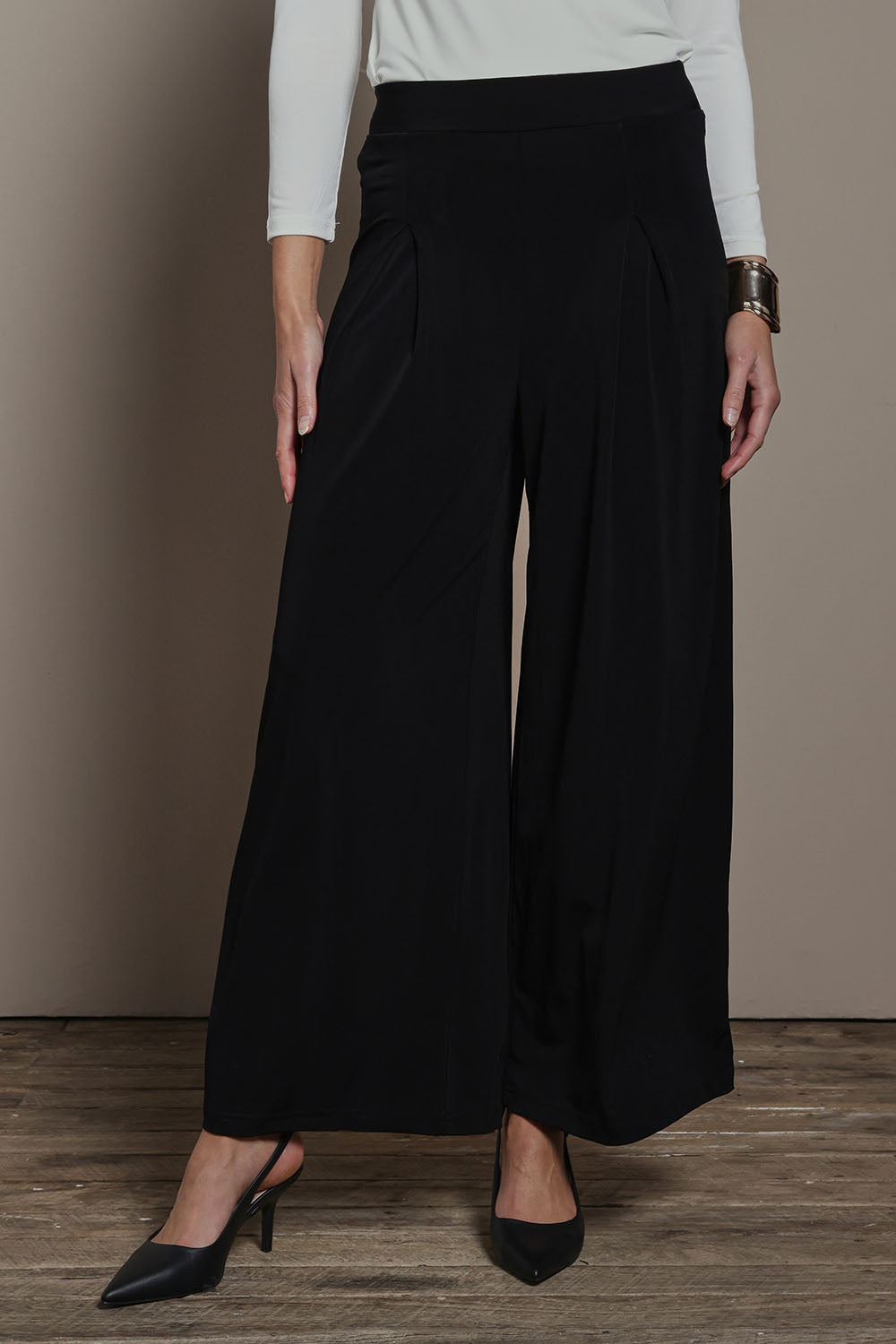 Model Madeline wearing size 10 of The Palazzo Jersey Pull On Pant in colour Black (Black), from the front, cropped image