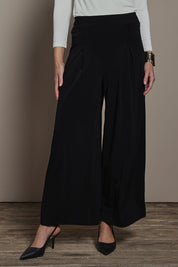 Model Madeline wearing size 10 of The Palazzo Jersey Pull On Pant in colour Black (Black), from the front, cropped image