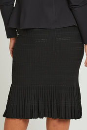 Model Ashleigh wearing size XL of The Textured Knit Frill Skirt in colour Black (Black), from the back