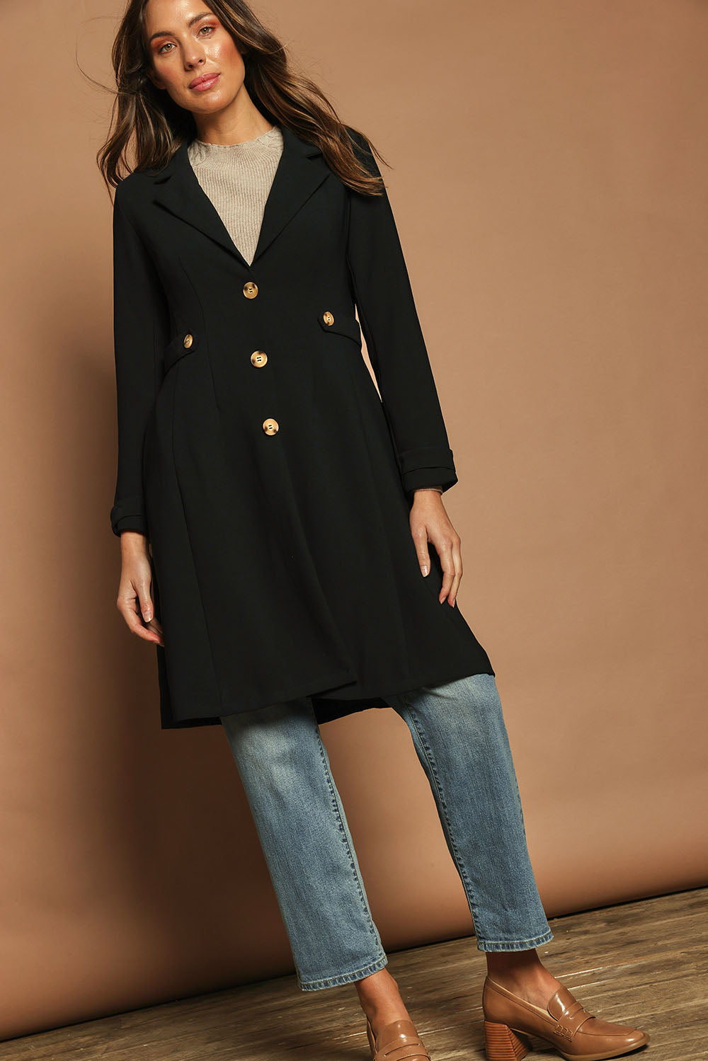 Model Madeline wearing size 10 of The Tab Detail Tailored Longline Coat in colour Black (Black), from the front, showing the whole outfit