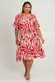 Model Ashleigh wearing size 16 of The Bubble Sleeve Button Through Dress in colour Abstract (Red), from the front, showing the whole outfit